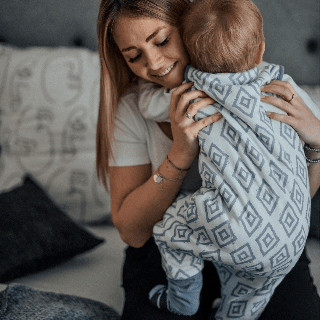 Baby im Schlafsack mit Füßen mit Mama